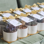 Load image into Gallery viewer, Row of potted plants with gold ribbons and labels

